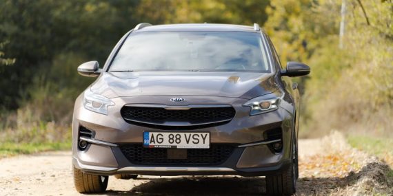Front view of a Kia car parked on a countryside road during autumn.